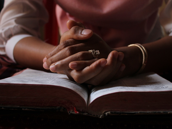 WOMAN READING BIBLE AND PRAYING